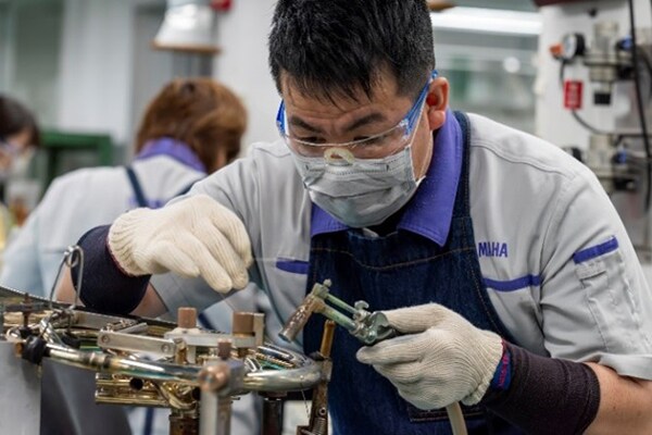 A craftsman soldering metal parts with lead-free solder.
