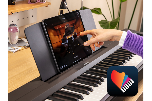 The Yamaha “Smart Pianist” app icon, together with a tablet placed on the music stand of the P-145BT
