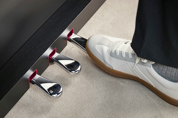 A right foot pressing the damper pedal