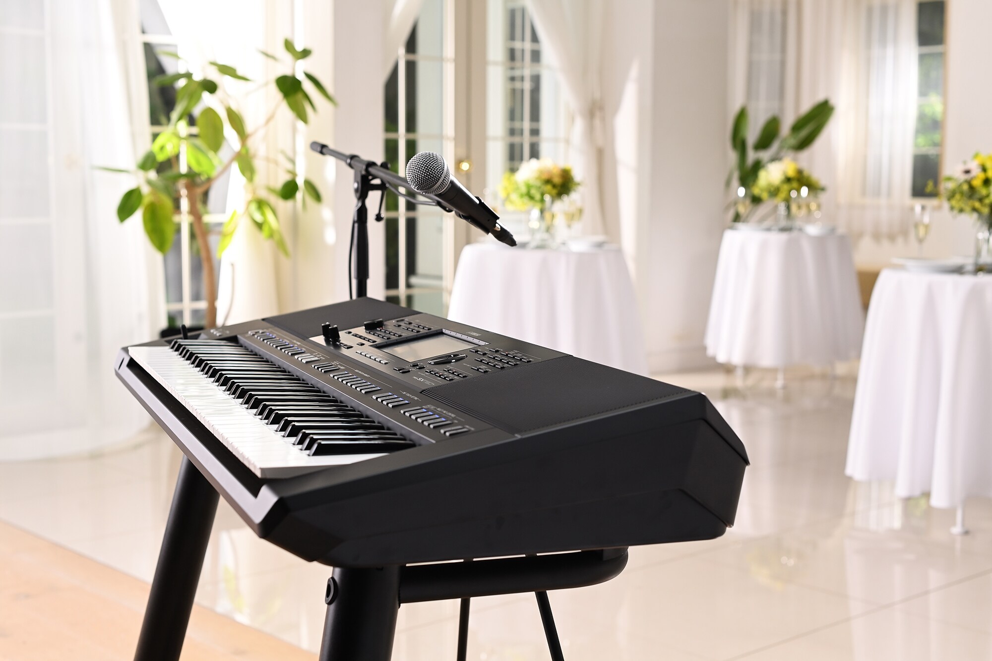 Yamaha Arranger Workstation PSR-SX720+ with microphone stand at a party venue