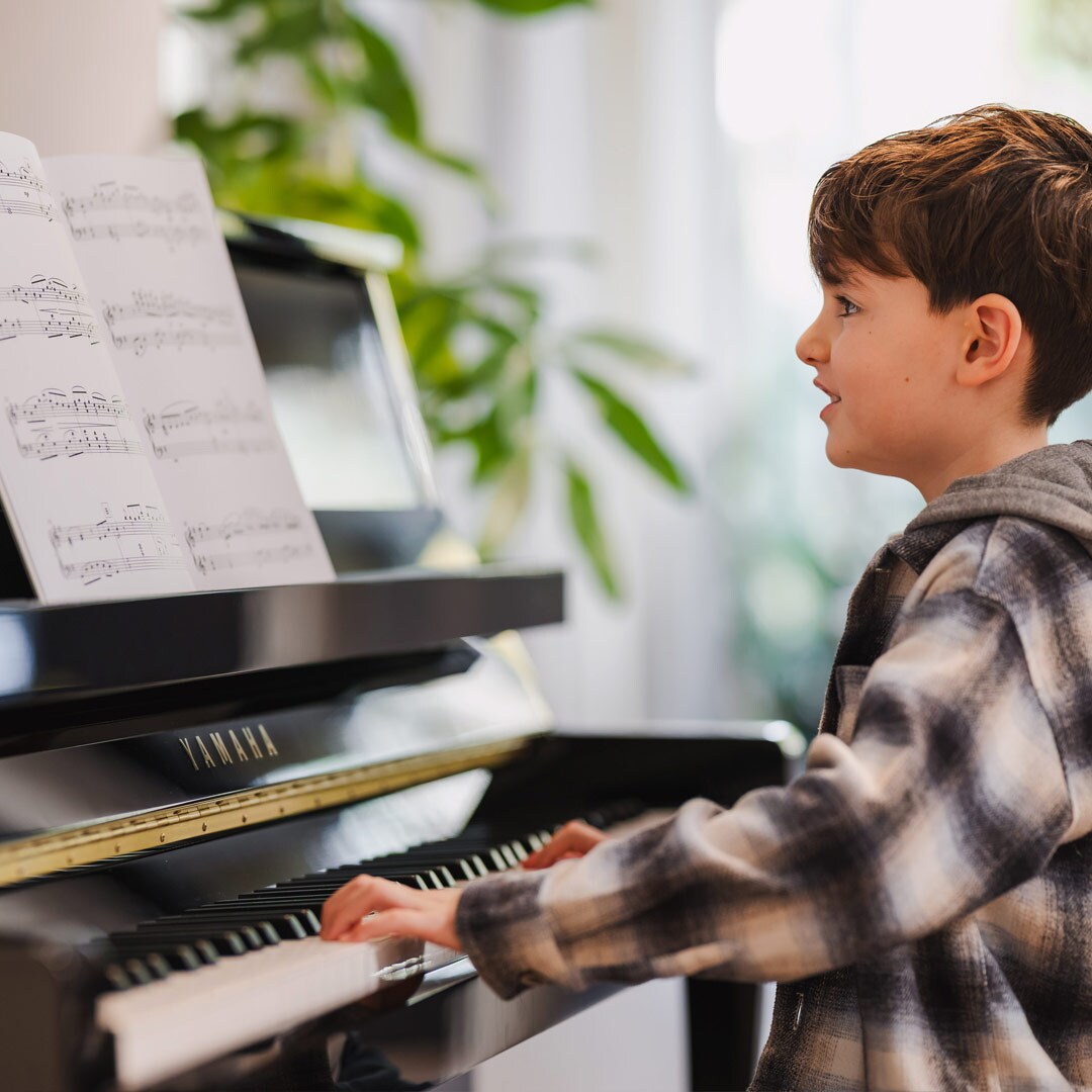 A child enjoys playing the upright piano B series